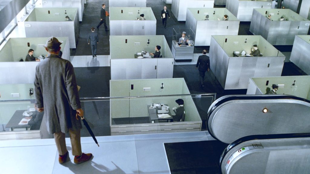 Playtime, scène de l'open space, où Hulot contemple de haut les bureaux carrés et ouverts où une multitude de gens se parlent sans jamais se voir.